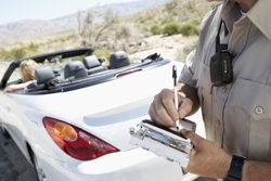 Policeman writing a Pasco County ticket - Pasco County red light ticket